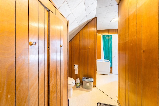 bathroom with toilet and wooden walls