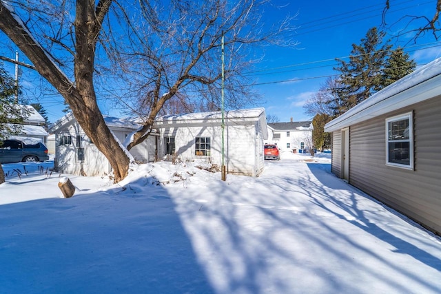 yard covered in snow with an outbuilding