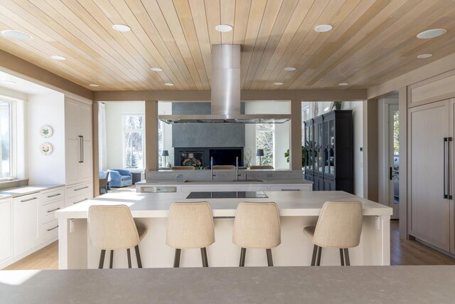 kitchen with white cabinetry, a breakfast bar, light countertops, and open floor plan