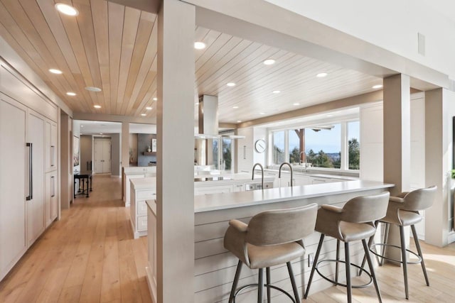 kitchen with light wood finished floors, wood ceiling, light countertops, white cabinetry, and recessed lighting