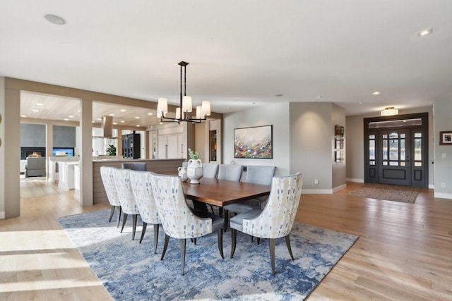 dining area with light wood-style floors, recessed lighting, baseboards, and an inviting chandelier