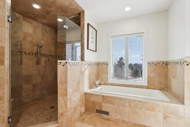 bathroom with recessed lighting, a garden tub, and tiled shower