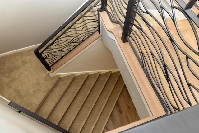 stairway featuring carpet and baseboards