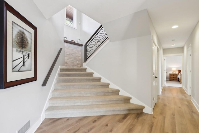 stairway with recessed lighting, wood finished floors, visible vents, and baseboards