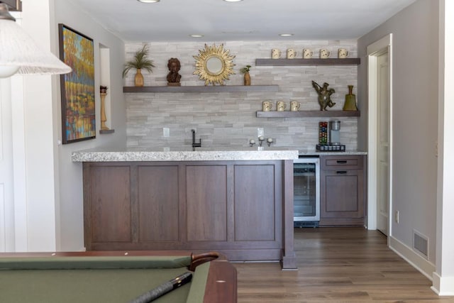 bar with beverage cooler, indoor wet bar, visible vents, and decorative backsplash