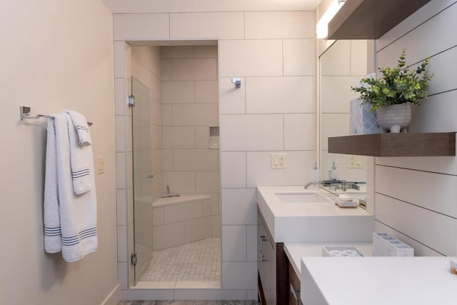 full bath with a shower stall, vanity, and tile walls