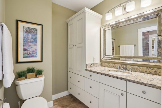 bathroom with vanity, toilet, and baseboards