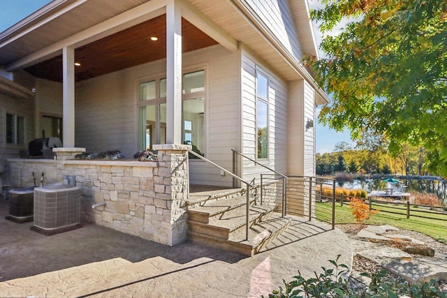 entrance to property featuring fence and central AC unit