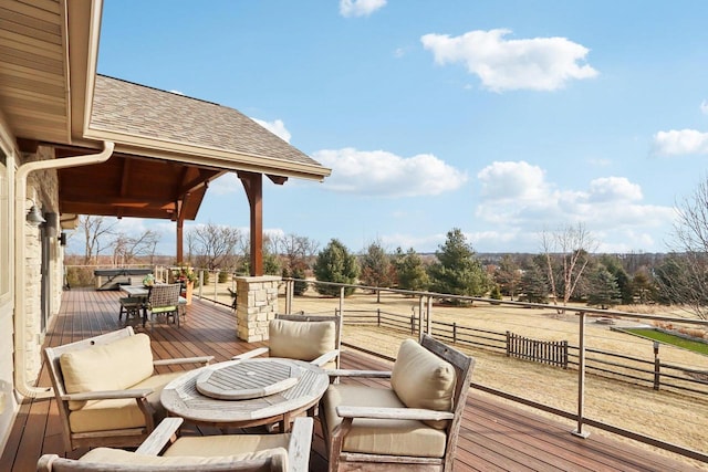 wooden terrace featuring outdoor dining space and a rural view