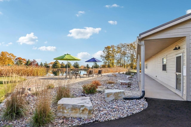 view of yard featuring a water view and a patio