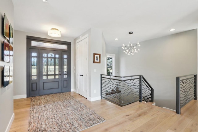 foyer entrance featuring light wood-type flooring, plenty of natural light, and baseboards