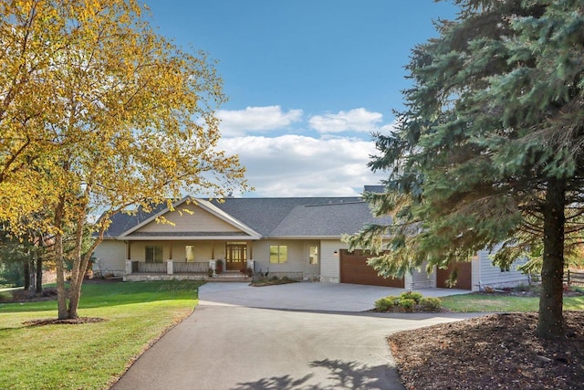 ranch-style house with a front yard, covered porch, driveway, and an attached garage