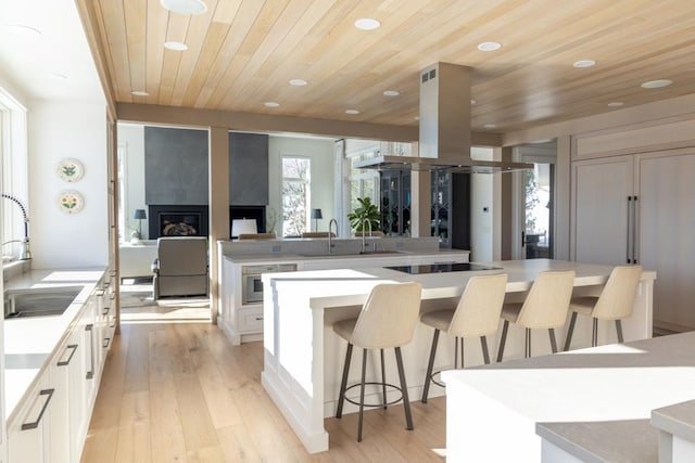 kitchen with a sink, white cabinetry, and a kitchen breakfast bar