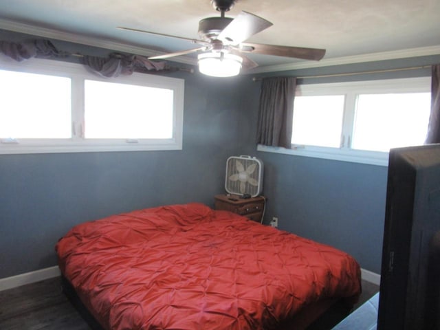 bedroom with crown molding, wood finished floors, a ceiling fan, and baseboards