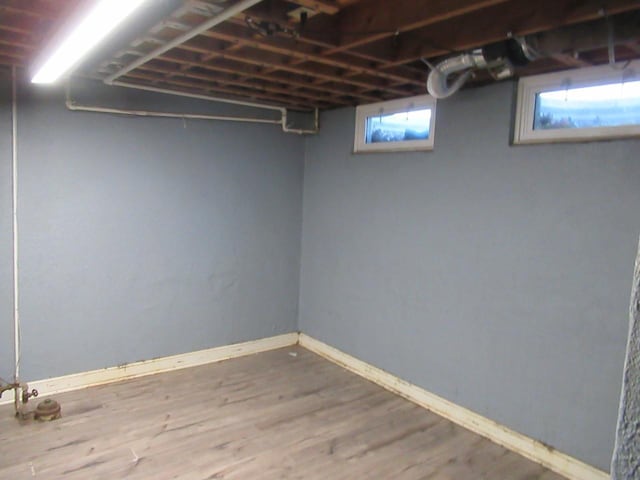 basement featuring baseboards and wood finished floors