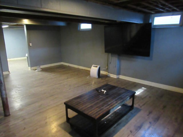 basement featuring a healthy amount of sunlight, baseboards, and wood finished floors