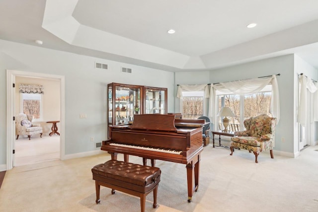 sitting room featuring a raised ceiling, visible vents, light carpet, and baseboards