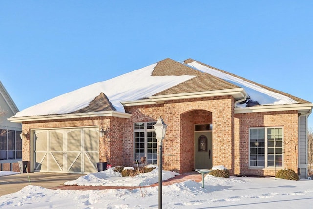 single story home with a garage and brick siding