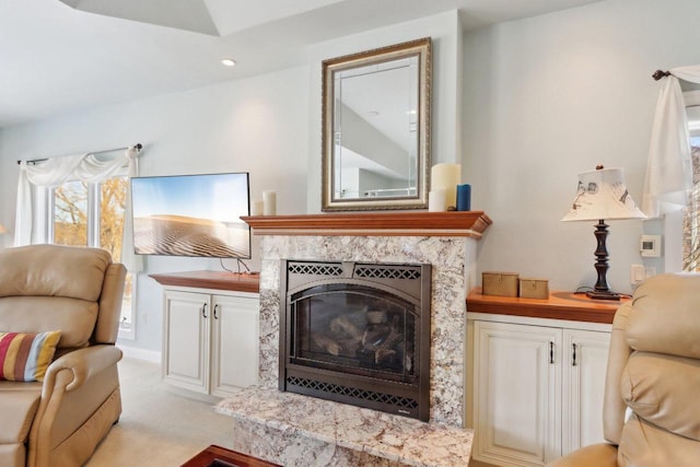 living area with a high end fireplace, light carpet, and recessed lighting