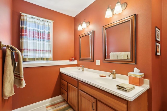 bathroom featuring a sink, baseboards, and double vanity