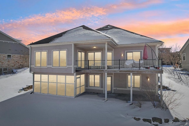 back of house at dusk with a balcony