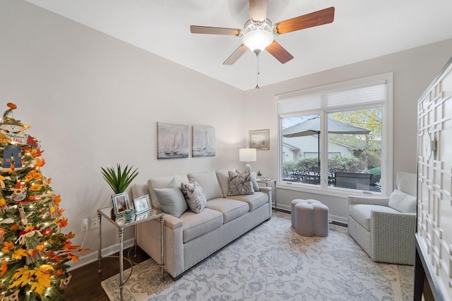 living room featuring light wood-type flooring, ceiling fan, and baseboards