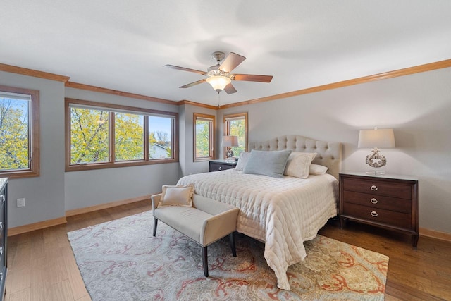 bedroom featuring baseboards, wood finished floors, a ceiling fan, and crown molding