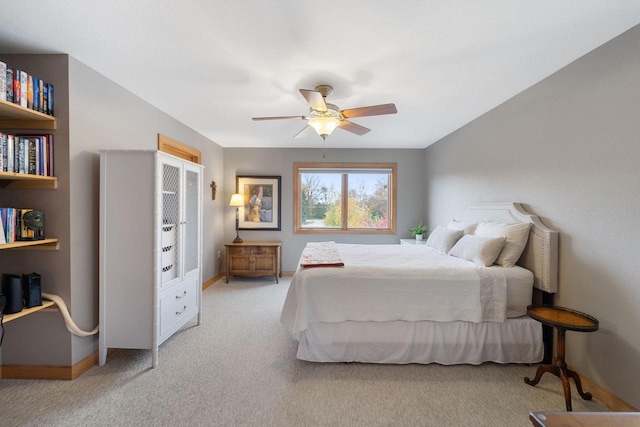 bedroom with light colored carpet, ceiling fan, and baseboards