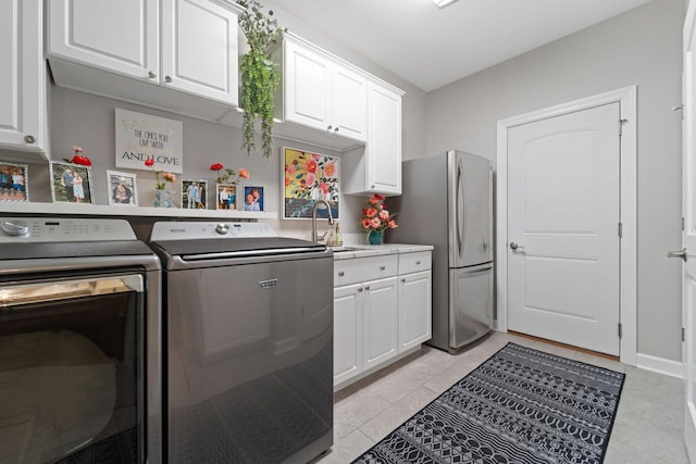 clothes washing area featuring cabinet space, a sink, and independent washer and dryer