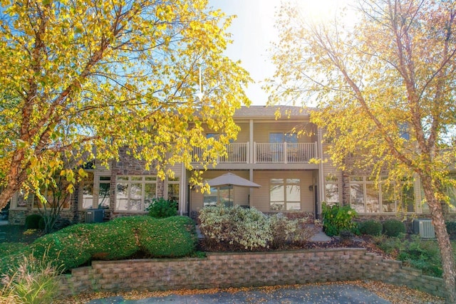 view of front of property featuring a balcony and central air condition unit