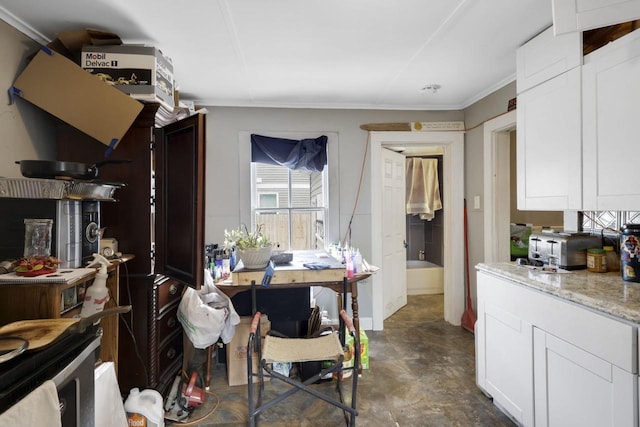 kitchen with white cabinetry, crown molding, and light stone countertops