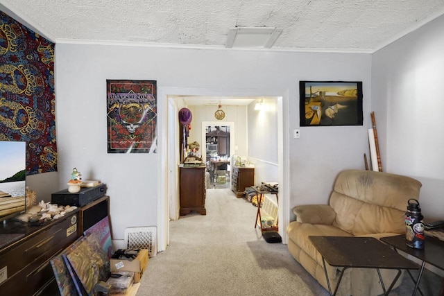 sitting room with ornamental molding, light colored carpet, and a textured ceiling