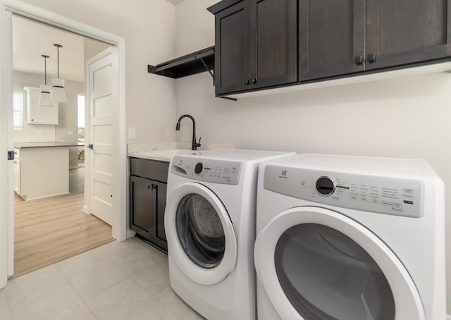 8012 Laufenberg Blvd, Cross Plains, WI 53528 - laundry room with cabinet space, washer and dryer, light tile patterned flooring, and a sink