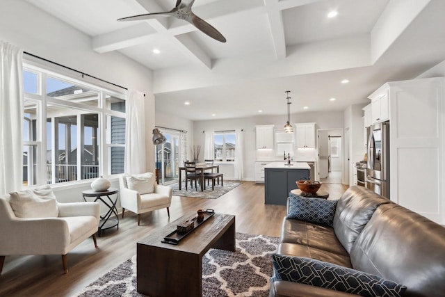 living room with light wood-style flooring, recessed lighting, coffered ceiling, a ceiling fan, and beam ceiling