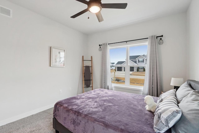 carpeted bedroom with a ceiling fan, visible vents, and baseboards