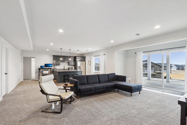 living room featuring recessed lighting, light carpet, and baseboards