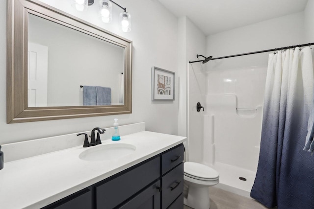 full bath featuring toilet, a stall shower, and vanity