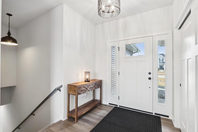 foyer featuring light wood-style floors and a notable chandelier