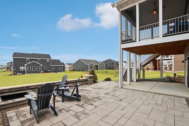 view of patio featuring a residential view, a sunroom, and stairs