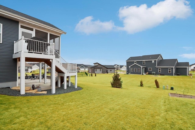 view of yard featuring a patio area, a residential view, stairway, and a sunroom