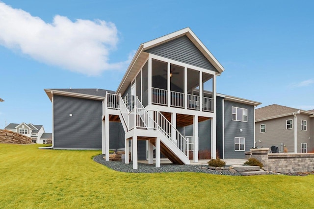 back of house featuring a sunroom, stairway, and a yard