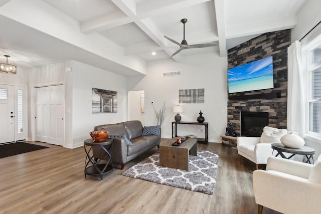 living area featuring baseboards, visible vents, coffered ceiling, wood finished floors, and a fireplace