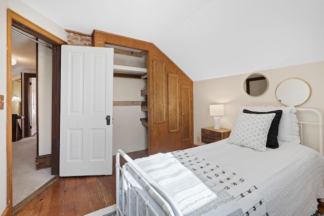 bedroom with dark wood finished floors and vaulted ceiling