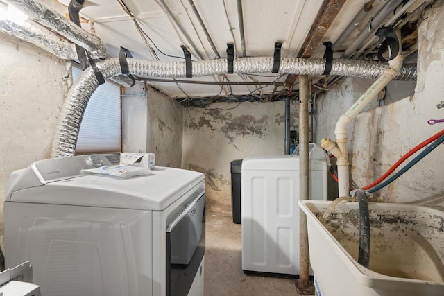 washroom with laundry area, washer and clothes dryer, and a sink