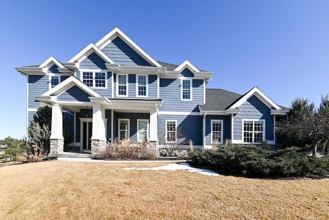 craftsman house featuring covered porch and a front lawn