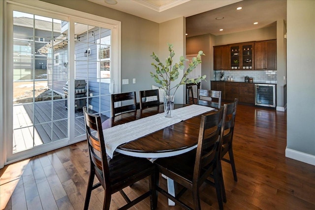 dining room featuring recessed lighting, beverage cooler, baseboards, and dark wood-style flooring