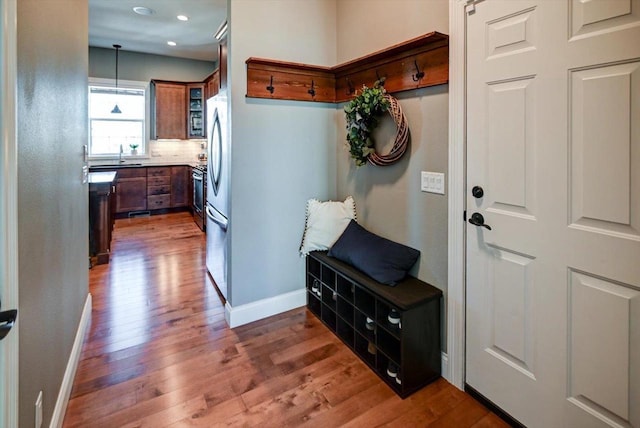 mudroom with a sink, recessed lighting, dark wood finished floors, and baseboards