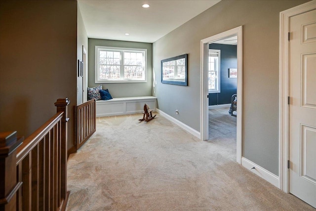 corridor featuring recessed lighting, light colored carpet, and baseboards