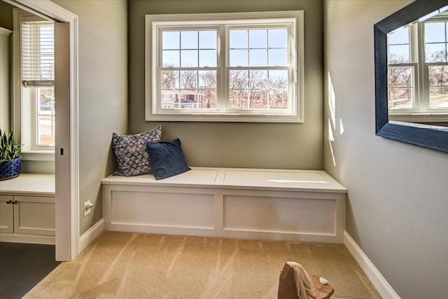 sitting room with baseboards and light colored carpet