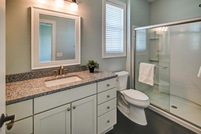 bathroom with vanity, tile patterned flooring, a shower stall, and toilet